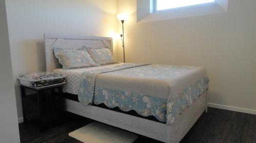 1 dormitorio con 1 cama con lámpara. en Afan Home of Joy, en Winnipeg