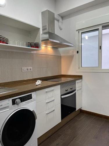 a white kitchen with a stove and a dishwasher at DREAM RAMBLA in Santa Cruz de Tenerife