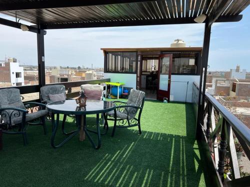 eine Terrasse mit einem Tisch und Stühlen auf dem Balkon in der Unterkunft Casa Villa Victoria en Pisco in Pisco