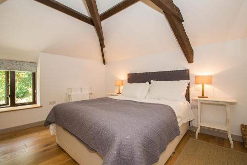 sypialnia z łóżkiem i dwoma lampami na dwóch stołach w obiekcie Lena Cottage at Wringworthy Farm on Dartmoor National Park, close to Tavistock, ideal base for exploring Devon and Cornwall, hiking, horse riding, golf, fuelled by green energy w mieście Marytavy