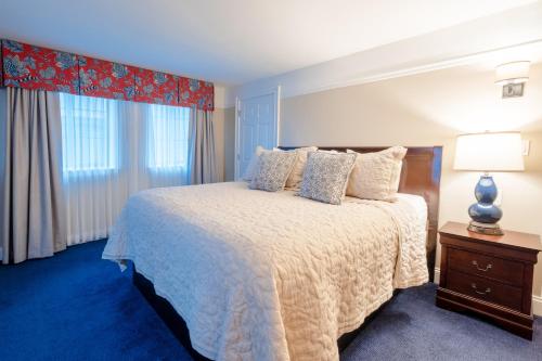 a bedroom with a large bed and a window at Red Coach Inn in Niagara Falls