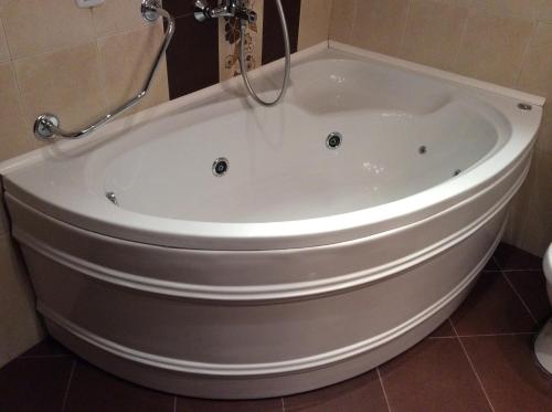 a large white bath tub in a bathroom at Gurko Hotel in Veliko Tŭrnovo