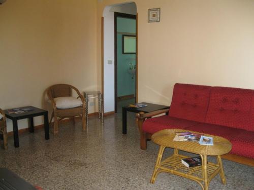 a living room with a red couch and chairs at Appartamento le castagnelle in Copersito
