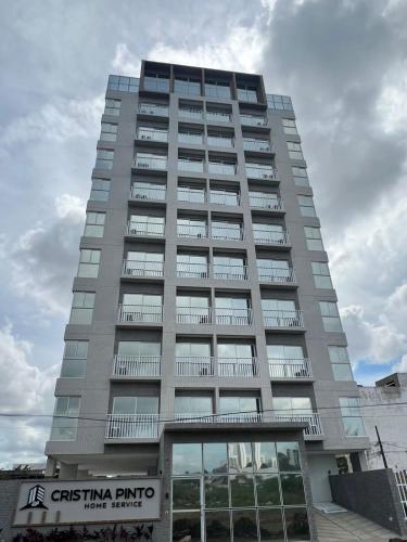 um edifício alto com um sinal em frente em Apartamento Alto Padrão - Com Ar em Campina Grande