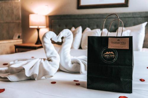 um saco de compras sentado numa cama com toalhas de cisne em Canmore Rocky Mountain Inn em Canmore