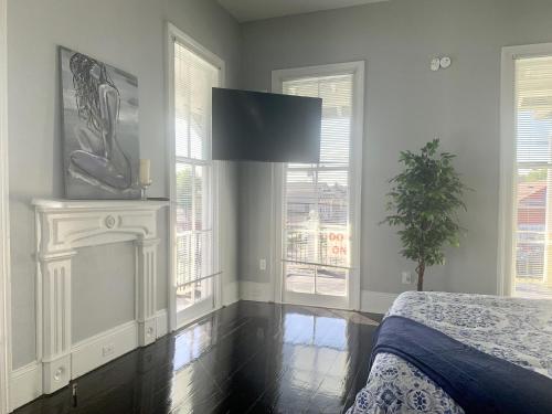 a bedroom with a bed and a fireplace and windows at The Balcony on St Ann in New Orleans