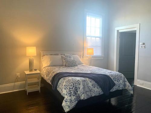 a bedroom with a bed and a table with a lamp at The Balcony on St Ann in New Orleans