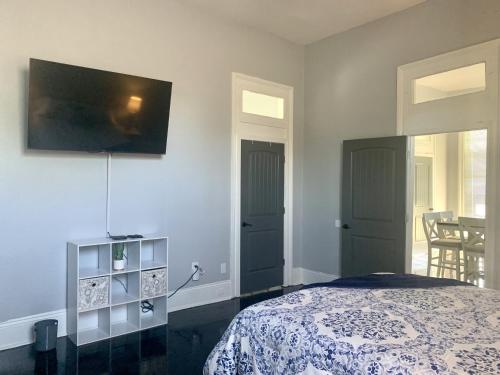 a bedroom with a bed and a tv on the wall at The Balcony on St Ann in New Orleans