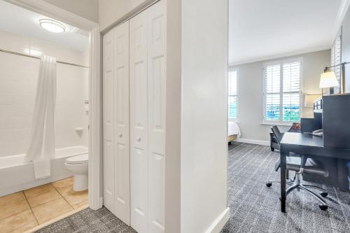 a bathroom with a toilet and a desk at Staybridge Suites Savannah Historic District by IHG in Savannah
