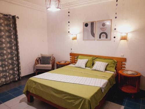 杜阿拉的住宿－Belappart. Peaceful, Free Wi-Fi & Parking.，一间卧室配有绿色的床和椅子