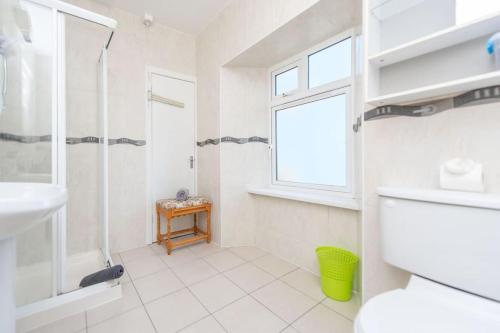 La salle de bains blanche est pourvue d'une douche et d'un lavabo. dans l'établissement Clonbur House - One bedroom apartment, à Galway