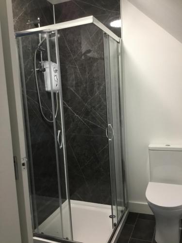 a shower with a glass door in a bathroom at Glenshee Guest House in Golspie