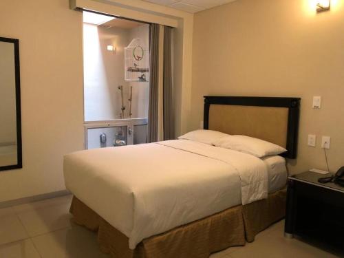 a bedroom with a large bed with a window at Hotel CH in Guadalupe