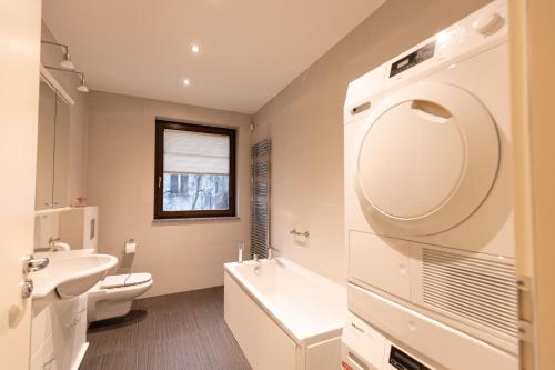 W łazience znajduje się umywalka, toaleta i lustro. w obiekcie Basha Apartment PREMIUM Sopot 2 w mieście Sopot