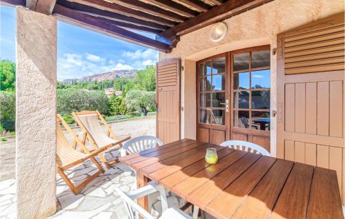 une table et des chaises en bois sur une terrasse dans l'établissement Domaine De La Bastide Da, à Agay