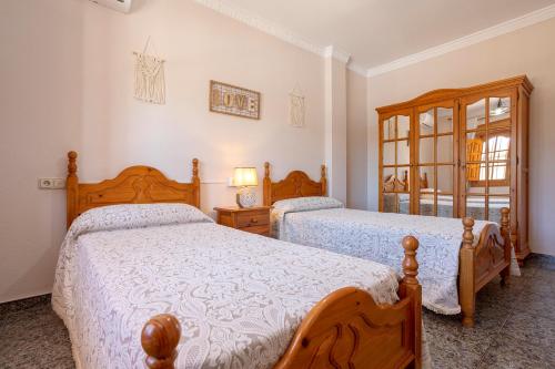 1 Schlafzimmer mit 2 Betten und einem Spiegel in der Unterkunft Casa Los Cortijillos in Alcaucín