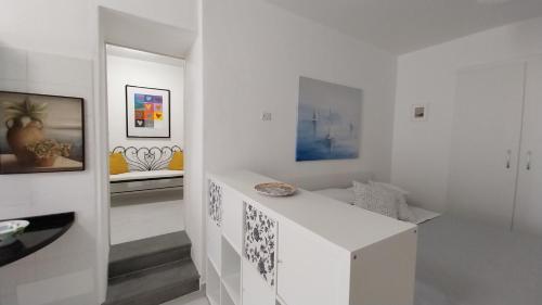 um quarto branco com paredes brancas e uma escada em Casetta Cirantò monolocale em Ischia