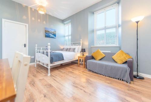 een slaapkamer met een bed en een bank bij Clonbur House - Studio village apartment in Galway
