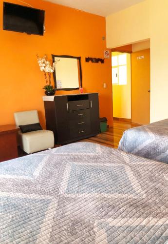 a bedroom with a bed and a dresser and a mirror at Hotel Jatziri in San Juan Teotihuacán