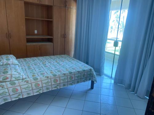 een slaapkamer met een bed en een glazen schuifdeur bij Beira Mar in Salvador