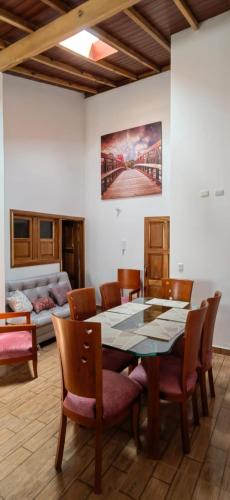 a dining room with a table and chairs and a couch at VILLA GÓMEZ in Zapatoca