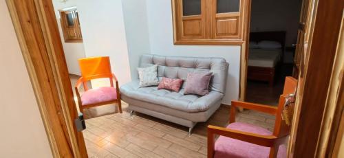 a living room with a couch with pillows on it at VILLA GÓMEZ in Zapatoca
