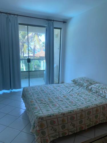 a bedroom with a bed and a large window at Beira Mar in Salvador