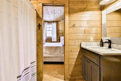 a bathroom with a sink and a bedroom at Ivylog Creek Getaway - STR License #00,7980 in Young Harris