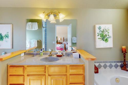 Un baño con lavabo, bañera y espejo. en Bello Lago Villa, en Pagosa Springs