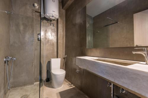 a bathroom with a toilet and a sink and a shower at White Pearl Apartments in Paralia Katerinis