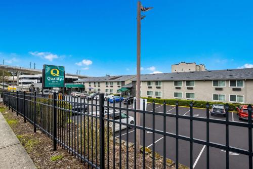 ein Zaun neben einer Straße mit Parkplatz in der Unterkunft Quality Inn SeaTac Airport-Seattle in SeaTac