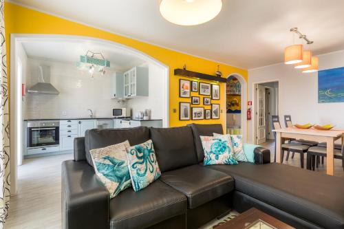 a living room with a couch and a kitchen at HC Torreira Beach in Torreira