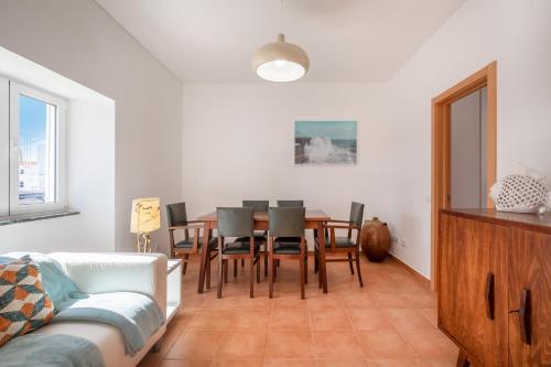 a living room with a dining room table and chairs at Casa 7 Gerações in Sagres