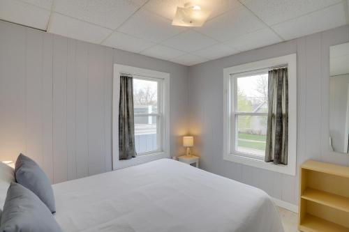 a bedroom with a white bed and two windows at Spacious South Haven Retreat Near Lake Michigan in South Haven