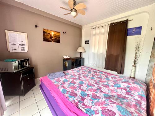 um quarto com uma cama e um micro-ondas em Papeete happiness pool and spas em Papeete