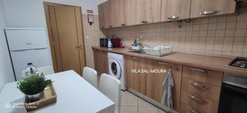 a kitchen with a table and a washing machine at Vila Sal-Moura DiscoverAlentejo in Moura