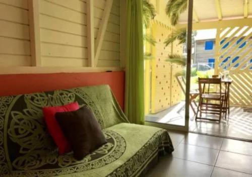 Zimmer mit einem Bett und einem Balkon mit einem Tisch in der Unterkunft Maison colibri in Les Anses-dʼArlets