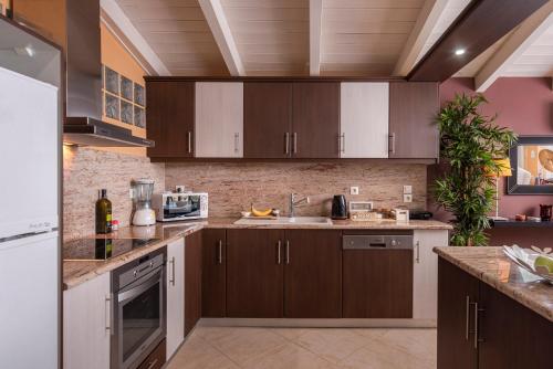 una cucina con armadi marroni e lavandino di Panoramic view!Penthouse 120qm of sea & mountain a Loutra Edipsou