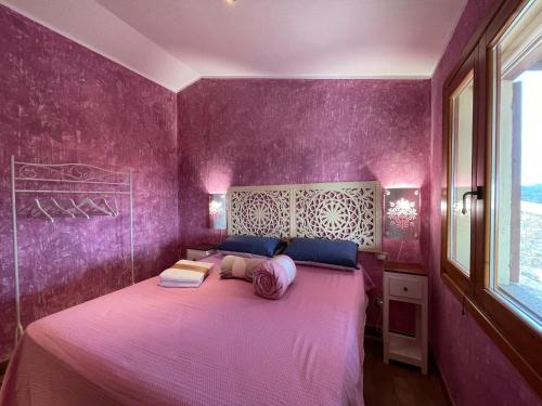a purple bedroom with a large bed with purple walls at Villa Rocce Rosse in Costa Paradiso