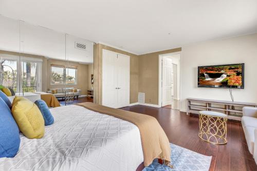 a bedroom with a large bed and a living room at A Stunning Beach villa Walking to Huntington Beach in Huntington Beach