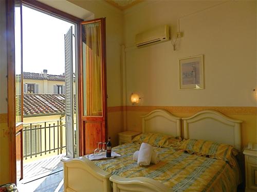 a bedroom with a bed and a balcony at Hotel Desirèe in Florence