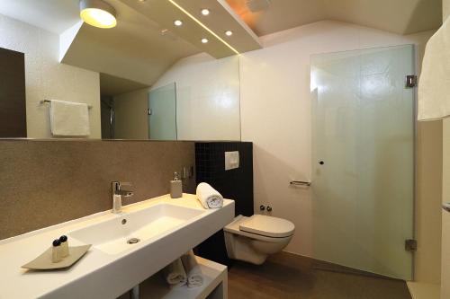 a bathroom with a sink and a toilet and a mirror at La Porta Luxury Rooms in Split