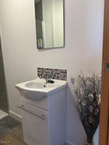 a white bathroom with a sink and a mirror at Alojamiento entero. Piso en el centro de El Vendrell. in El Vendrell