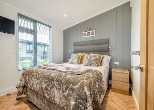 a bedroom with a large bed and a window at Midsomer Lodges in Pilton
