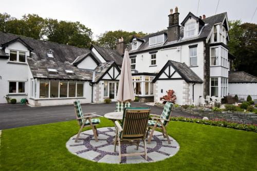 a house with a table and chairs in the yard at Hawksmoor Guest House in Windermere
