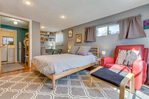 een slaapkamer met een bed en een rode stoel bij Platt Park Studio - 4 Miles from Downtown Denver! in Denver