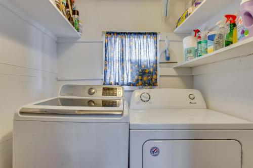 a small kitchen with a stove and a washing machine at Platt Park Studio with Patio Walkable Location! in Denver