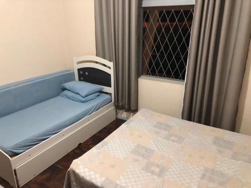 a small room with a bed and a table at Sítio dos Guedes in Guapimirim