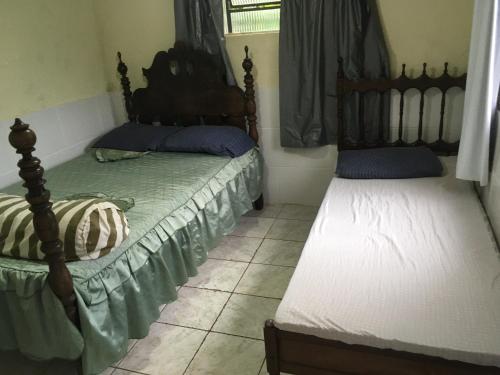 a bedroom with two beds and a window at Sítio dos Guedes in Guapimirim