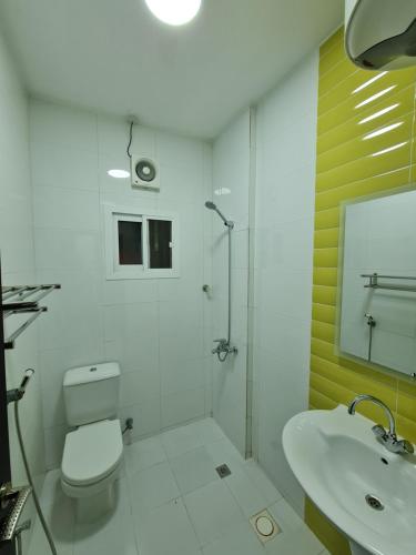 a bathroom with a toilet and a shower and a sink at هومينج - Homing (شقق مفروشة) in Salalah